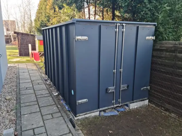 Nowoczesna elewacja z blachy na rąbek stojący wykonana na domku narzędziowym. Pokazujemy, że technologia rąbka to nie tylko kominy, ale też trwałe i estetyczne wykończenie mniejszych obiektów. Ligota Piękna