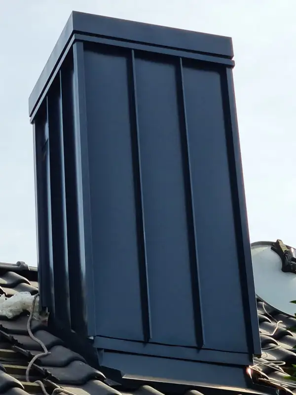 Obróbka komina rąbek stojący w kolorze antracytowym. Kompletna zabudowa ścian komina wraz z dopasowaną czapą blaszaną, zapewniająca estetyczny wygląd i 100% szczelności na lata. 